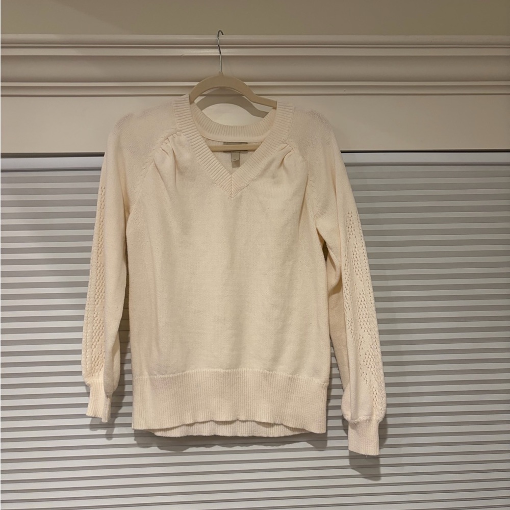 White sweater with detailing up the sleeves